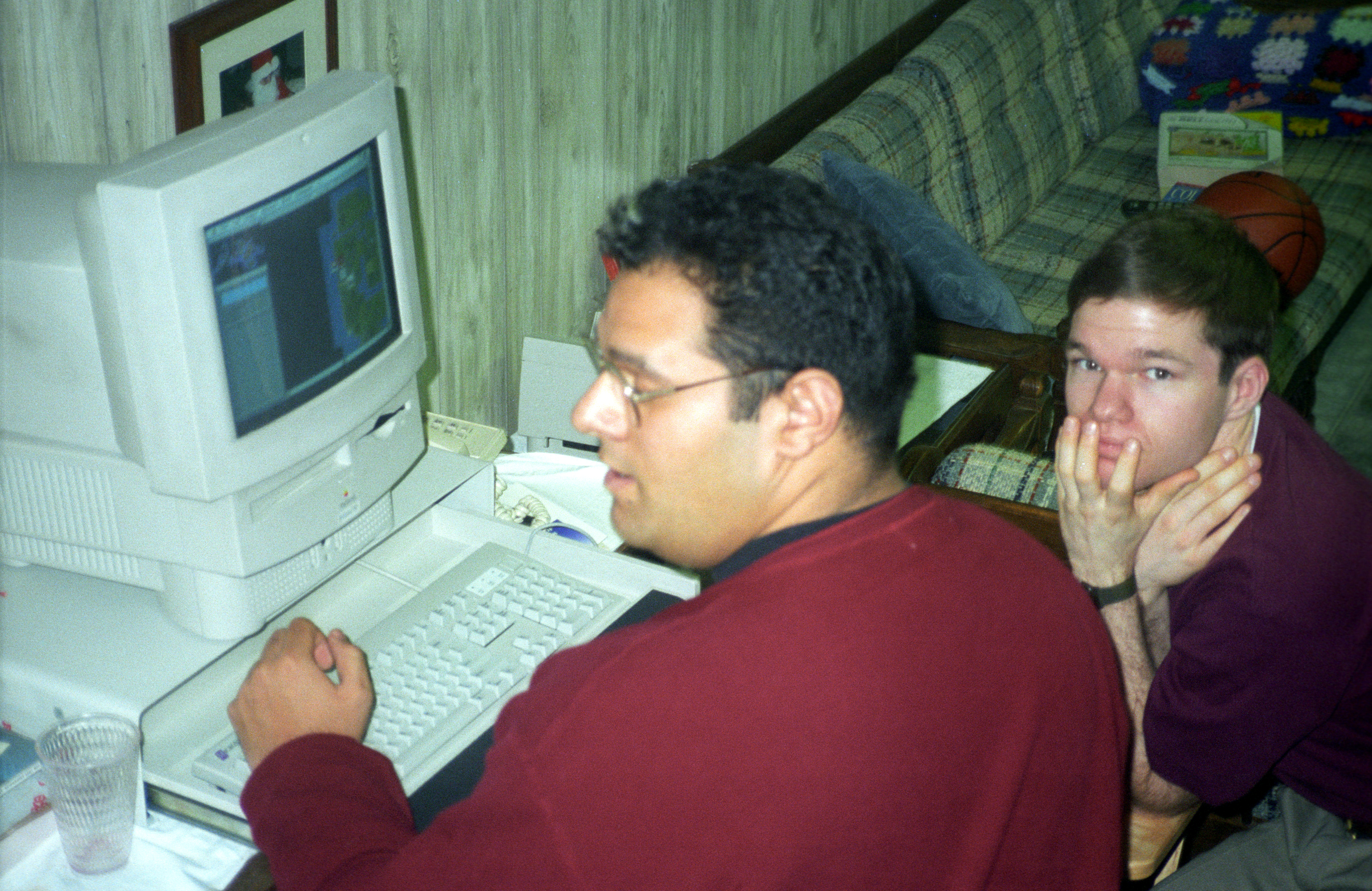Two young men using a Macintosh computer in a basement, 1995